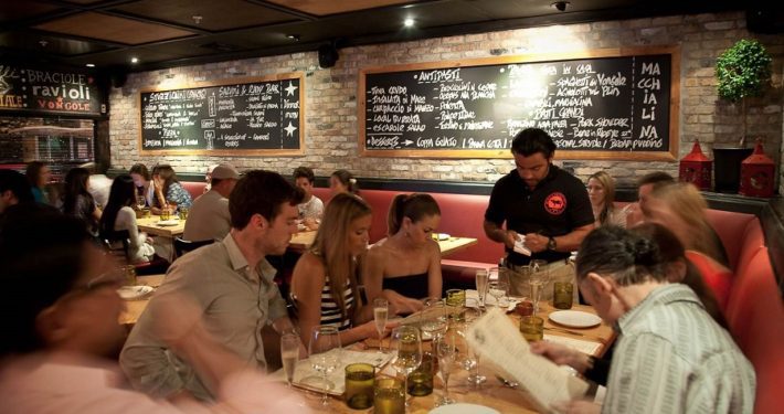 A group of people sitting at tables in a restaurant.