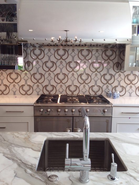 A kitchen with a sink, stove and oven.