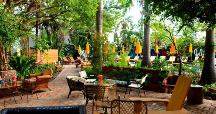 A patio with tables and chairs in the middle of a park.