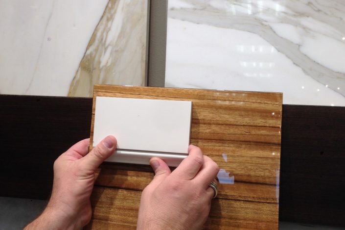 A person holding an object on top of a wooden table.