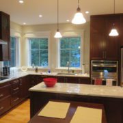 A kitchen with brown cabinets and white counter tops.