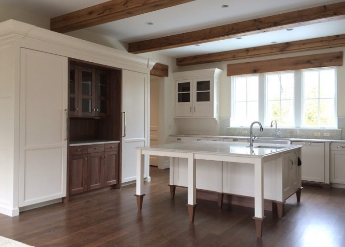 A kitchen with wooden floors and white cabinets.