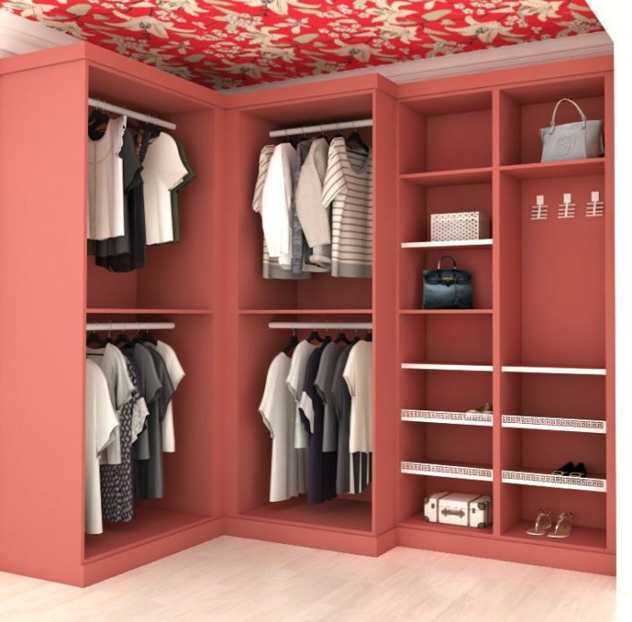 A red closet with clothes hanging on the racks.