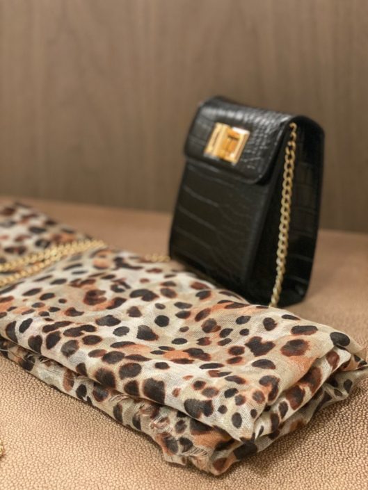 A black purse and leopard print bag on display.