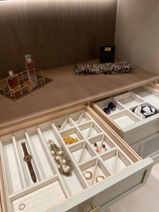 A drawer with many compartments and a tray for jewelry.