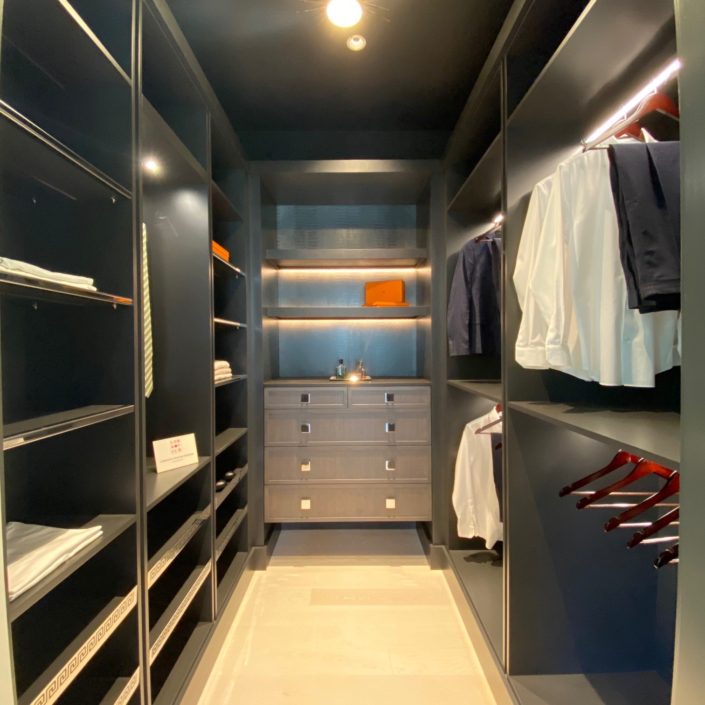 A walk in closet with shelves and drawers