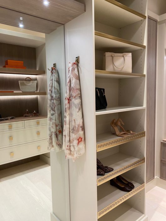 A closet with shelves and clothes hanging on it.