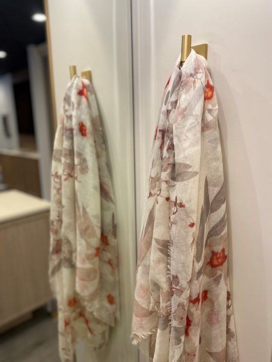 A mirror with two scarves hanging on it.