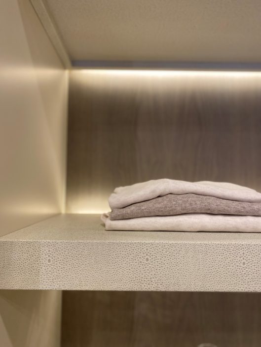 A pile of folded towels on top of a shelf.